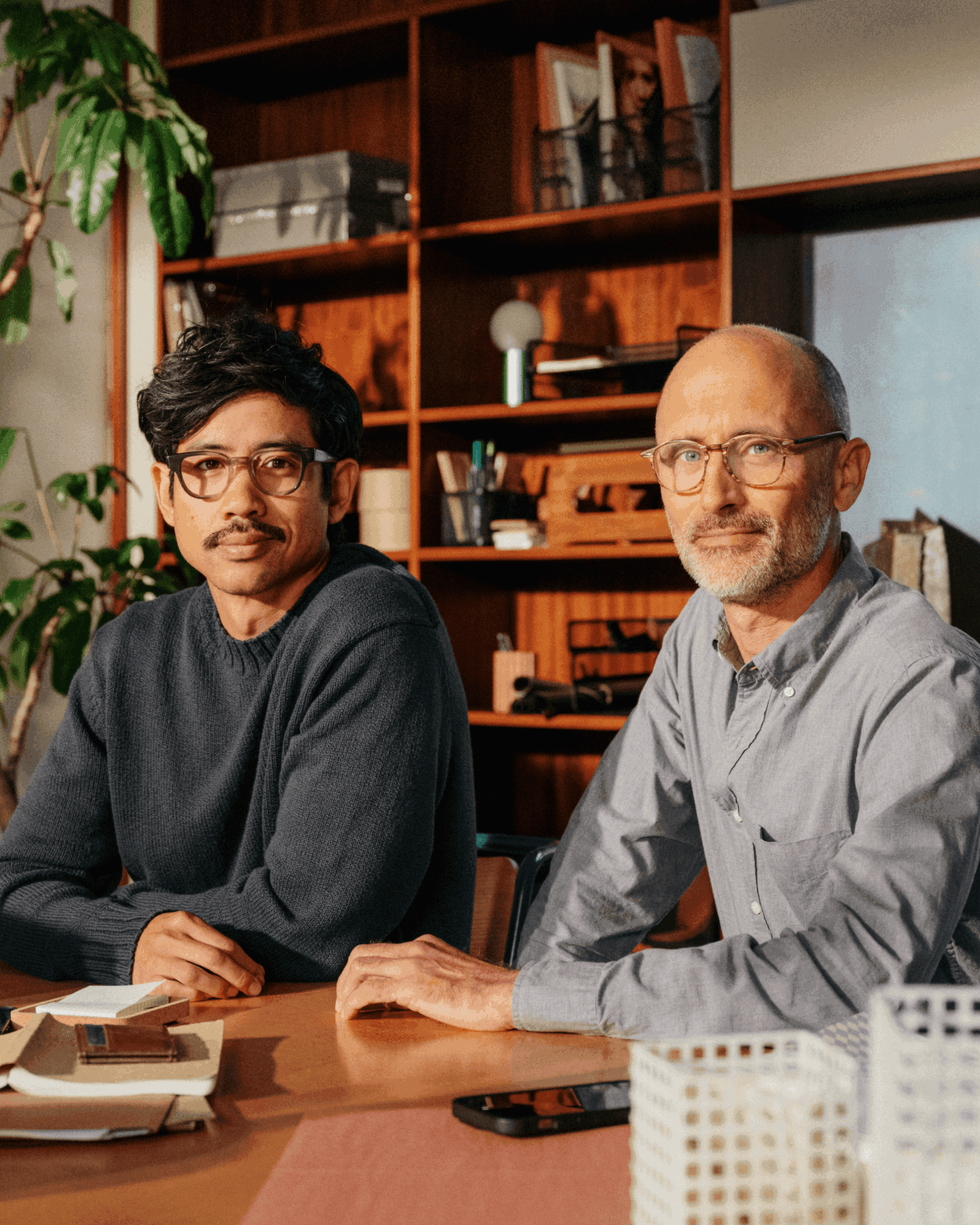 Two men sitting in an office space with warm tones